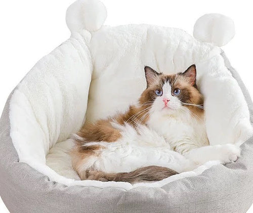 Cat lying in a fluffy pet bed with white interior and gray exterior